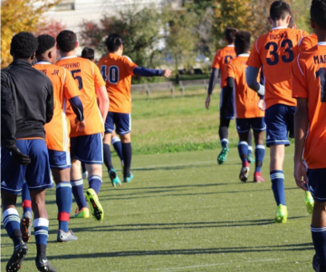 A group of young men playing soccer on a field.